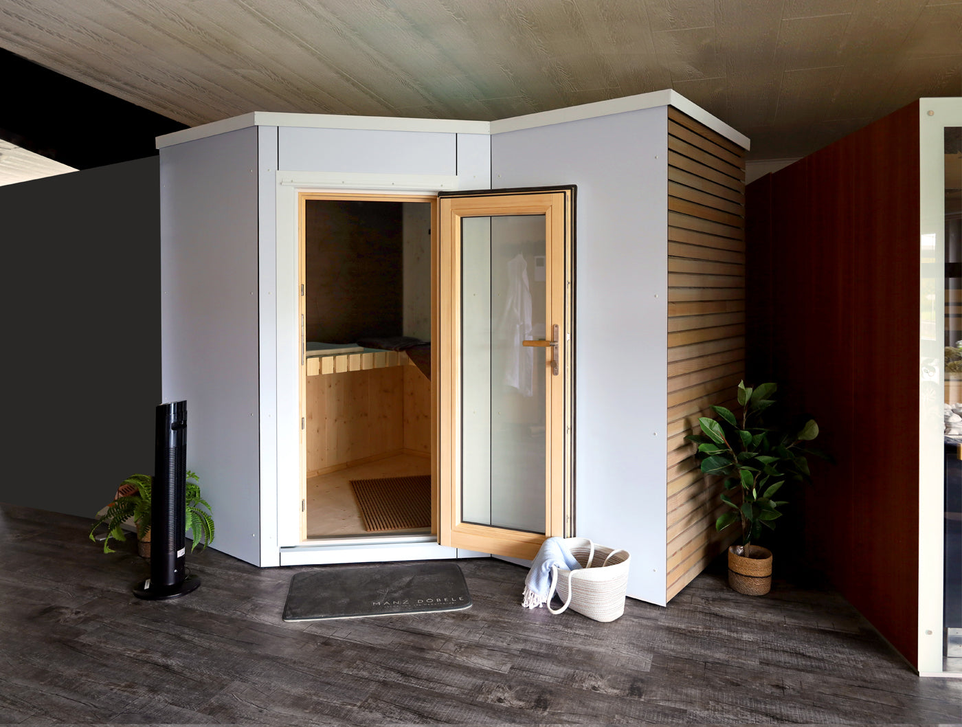 Außensauna aus massivem nordischen Fichtenholz, Außenverkleidung in weißem Kunststoff-Vollkernplatten mit glatter Oberfläche, Außentür in Holz-Alu Konstruktion mit Glas