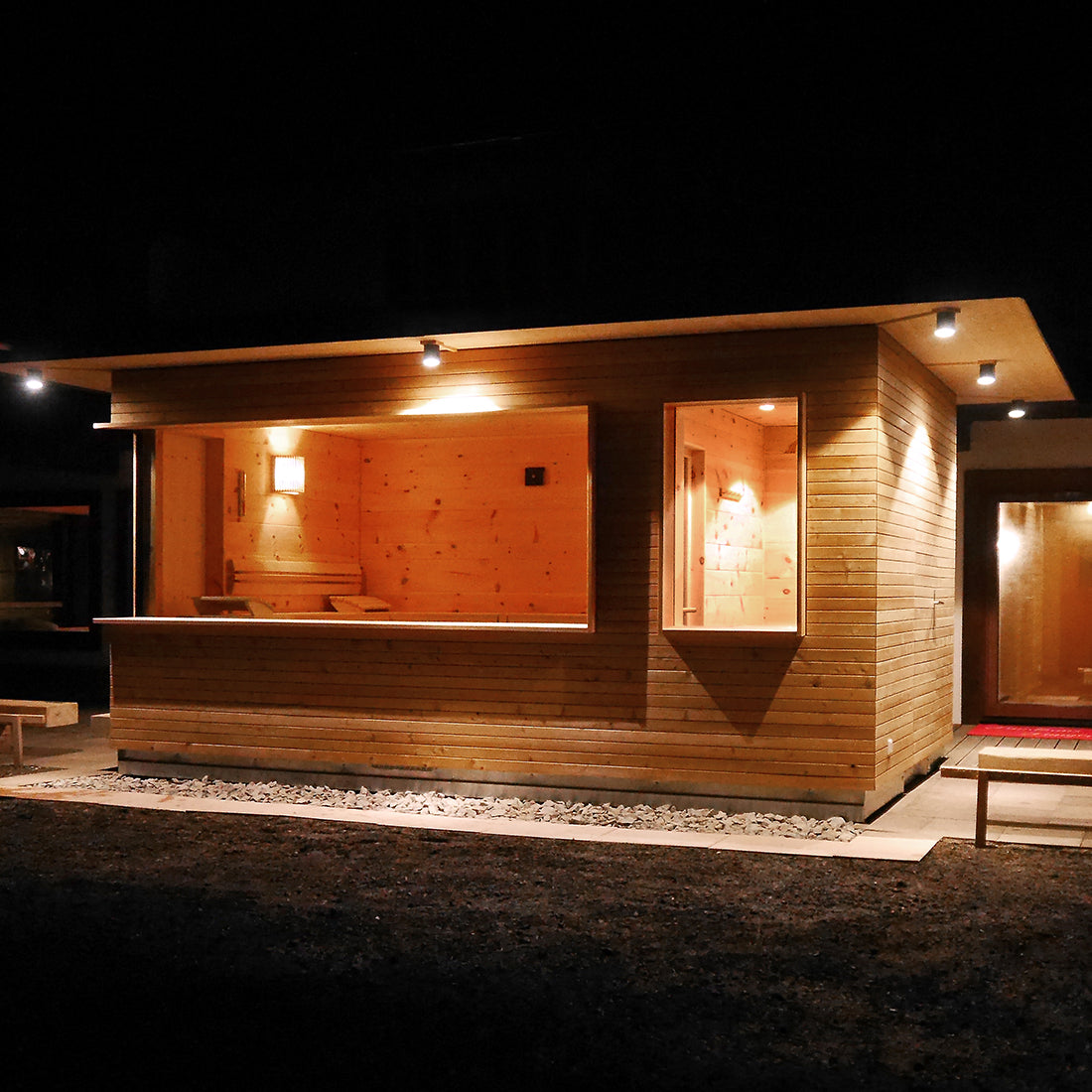 Außensauna mit Vorraum und großzügiger Festverglasung, Außenverkleidung in Profilholz.